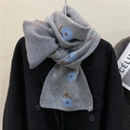 Gray knitted scarf with blue floral patterns styled on a long black wool coat - Gray