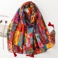 Écharpe bohème rouge style ethnique avec motifs patchwork et glands sur une surface blanche - Dégradé Rouge Jaune
