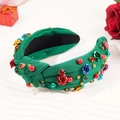Cerchietto annodato in tessuto verde con perline colorate e strass floreali su sfondo bianco - Verde