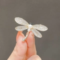 Silver dragonfly brooch with sparkling crystals and white pearls shown in hand - 173# Dragonfly