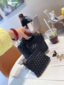 Mini hand-woven black bucket bag with matching small pouch on a cafe table - Black
