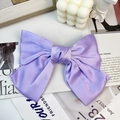 Detailed close-up of a large lavender satin bow hair clip with a silky texture and gloss - Purple (Duckbill Clip)