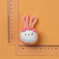 Handmade knitted pink ear mascot showing height of 9cm and width of 5.5cm with ruler measurement - Orange Dumpling Rabbit Doll