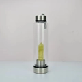 Clear glass water bottle featuring a large yellow-green hexagonal crystal prism insert - Citrine Bottle