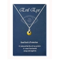 Detail of yellow evil eye charm necklace on blue display card with protective message - Steel Color Yellow Bead (Black Eye)