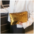 Close-up of golden sequin clutch bag detail with reflective metallic finish - Gold