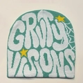 Detail of mint green knit beanie featuring white graffiti letters and yellow star embroidery - Light Green with White Letters