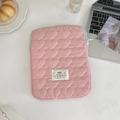 Pink heart-quilted iPad sleeve with green zipper and happy patch on white desk - 11" / Pink