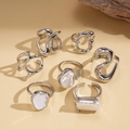 Dettaglio di 7 anelli d'argento minimalisti con accenti di perle e texture lava - Argento