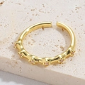 Adjustable golden open ring featuring seven sparkling pink gemstones on a stone pedestal - Flower Pink Zirconia Style