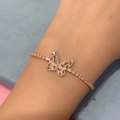 Detail of a gold butterfly bracelet with pink marquise zircon stones on a model's wrist - Butterfly - Gold