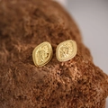 Macro shot of gold butterfly earrings with embossed floral details on vintage stones - Vintage Embossed Oval (EH126)