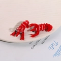 Macro-opname van twee creatieve rode glazen kreeftbedeltjes met oogjes voor DIY-sieraden - Rood