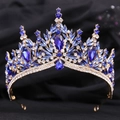 Close-up of golden bridal crown with deep blue and clear crystals on dark fabric - KC Gold White & Blue Rhinestone
