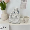 Détail du sac en toile avec motifs floraux bleus et bordure en dentelle élégante - Blanc