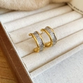 Detailed close-up of 18k bicolor gold C-shaped earrings with textured silver inner surface - Gold (Silver Earring Post)