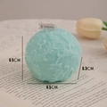 Mint green floral relief ball scented candle on an open book for cozy home decor - Macaron Lake Green Floral Sphere (Blackberry & Basil)