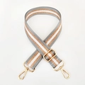 Close-up of adjustable striped nylon bag strap with gold metal hooks and texture - Gray