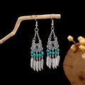 Macro detail of Bohemian silver earrings with turquoise beads and metal feather charms - E2870-1 Blue Rhinestone Feather