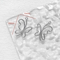 Detail von zwei silbernen Schmetterlingsanhängern mit 19x20mm Maßen auf weißem Grund - Schmetterling