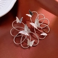 Detail of silver twisted metal flower wreath earrings with butterfly accents on satin - Silver Butterfly Stud Earrings (Silver Pin)