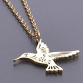 Detailaufnahme eines goldenen Kolibri-Anhängers mit floralen Gravuren und einer Gliederkette - Halsketten-Set / Gold