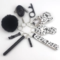 Detail view of a cow print self-defense keychain set including alarm and accessories - 5-Cow Print