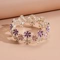 Détails d'un bracelet vintage avec des fleurs en émail violettes et une finition argentée - Violet
