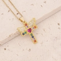 Detailed macro of golden cross pendant with angel wings and vibrant multi-color gemstones - Angel Wings Cross