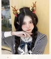 Brown reindeer antler headband with pine cones and berries worn by a female model - Pistachio Antler Style