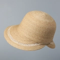 Dettaglio della fitta trama intrecciata e del motivo a onde bianche sul cappello di paglia - Cachi