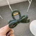 Close-up of deep green bow hair claw clip with glossy finish and gold metal spring - Approx. 8cm / Dark Green