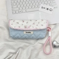 Detailed view of floral and quilted light blue pencil case on a white laptop setup - Pink Floral + Light Blue Heart