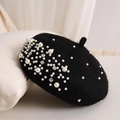 Close-up of black wool beret featuring elegant white pearls and sparkling rhinestones - Black