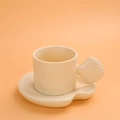 Beige ceramic coffee mug with shell-shaped handle and matching shell saucer - Shell Shape Cup + Saucer - Apricot