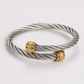 Primer plano de la pulsera de cable trenzado plateado con extremos dorados y texturas - Cable de Acero con Puntas Doradas