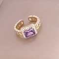 Detail eines goldenen Rings mit lila Zirkonia und schimmernden Mikrokristallen - Einstellbar Offen / Lila
