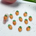 Detail view of 3D carrot nail art charms with orange resin and green leaves - 08 Carrot