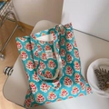 Detailed view of floral canvas tote bag with teal Indian print and woven handles - Blue Red Orange Floral