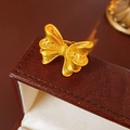 Dettaglio anello a fiocco dorato con lavorazione filigrana e texture spazzolata a vista - Oro