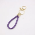 Close-up of purple braided leather keychain with golden metal ring and swivel clasp detail - Purple
