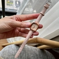 Nahaufnahme von rosa Lederarmband und roségoldenem quadratischem Zifferblatt am Handgelenk - Rosa Armband