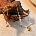 Elegant gold chain necklace featuring white pearls and a metallic flower pendant - Flower Pendant / Gold/White