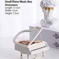Detail of white mini piano music box with transparent lid and gold mechanical parts - Small Piano Clockwork Music Box