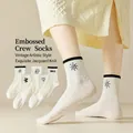 White crew socks with 3D embossed jacquard patterns including sun and bear designs - One Size / Black Relief