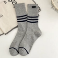 Graue Baumwoll-Mittelsocken mit marineblauen Streifen und Stoffetikett in Flachlage - Einheitsgröße / Hellgrau