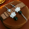 Détail de boucles d'oreilles lotus en argent avec perles vertes et glands sur boîte - Noir