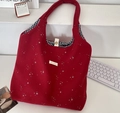 Détail du sac cabas rouge en toile avec motif étoile, doublure à carreaux et bouton pression - Bordeaux