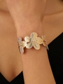 Dettaglio del bracciale a polsino floreale dorato con petali testurizzati al polso - Bracciale Rigido a Fiore Oro (A-163)