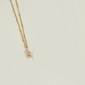 Golden necklace with S letter pendant and white pearls on a minimalist background - Letter S